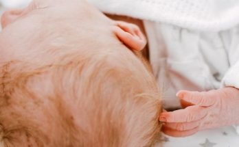 baby scratching back of head