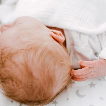 baby scratching back of head