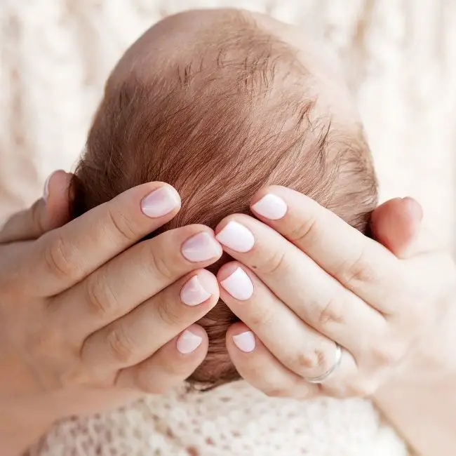 baby scratching back of head