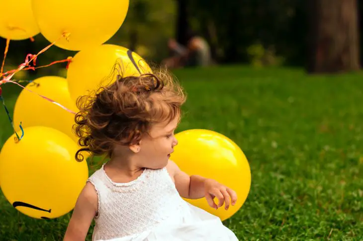 child with yellow balloons