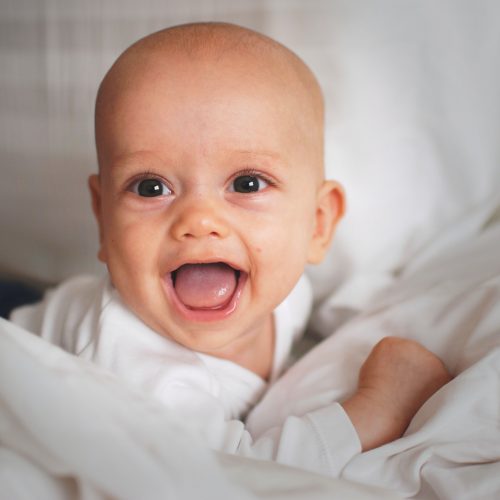 baby smiling with tongue out