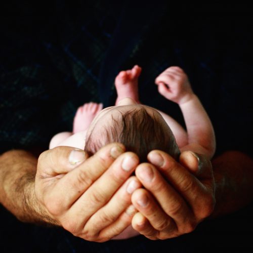 newborn sleeping in hands