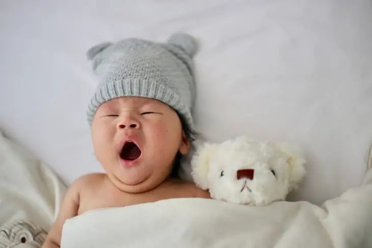 yawning baby's gray knit hat