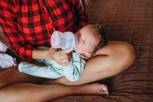 baby drinking milk from feeding bottle