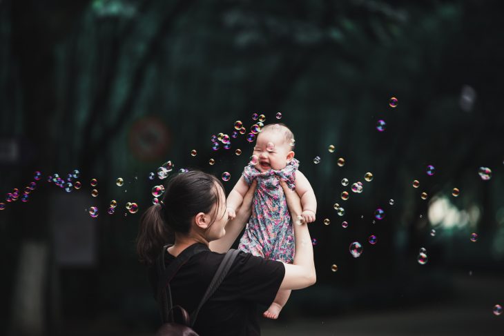 Baby infant with her mother in the garden