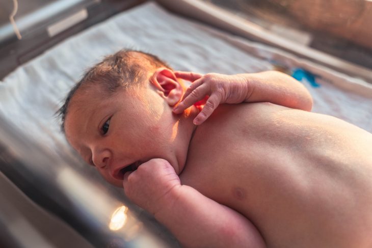 newborn on white textile