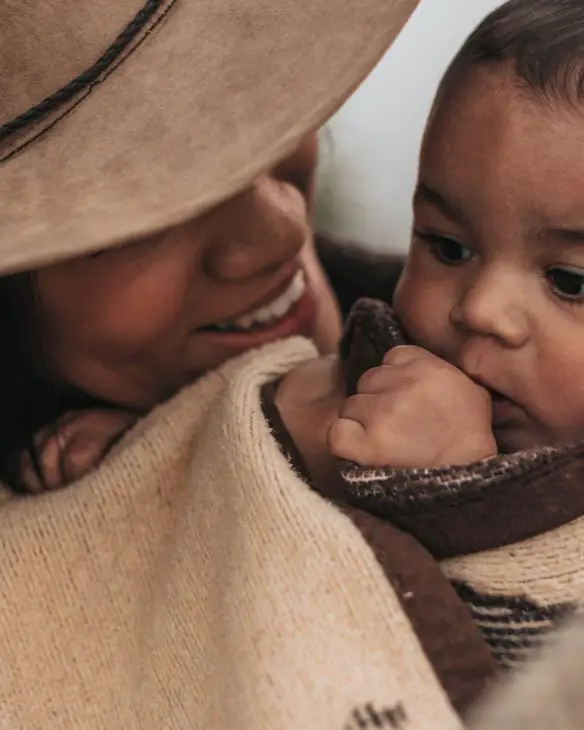 woman in hat carrying baby