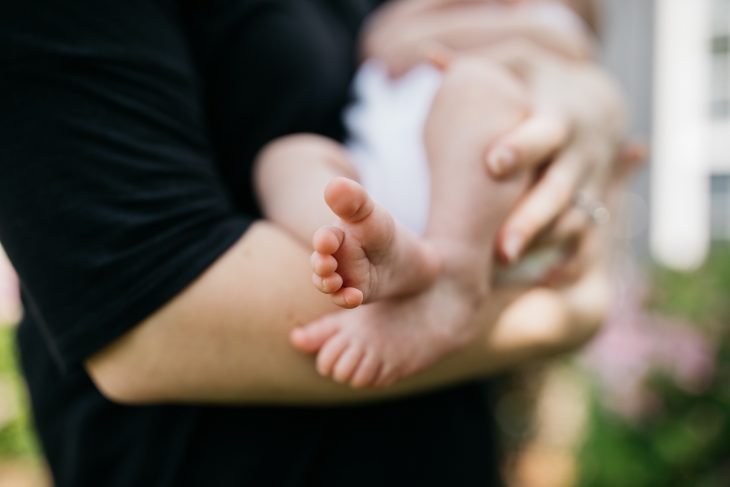 person carrying baby in arms